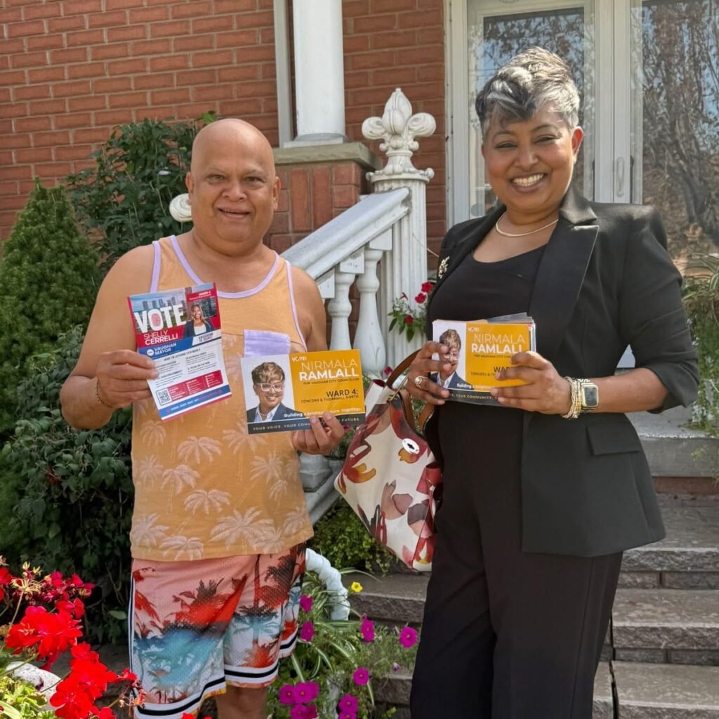 Nirmala Ramlall with a resident outside his home in Ward 4, both holding campaign literature
