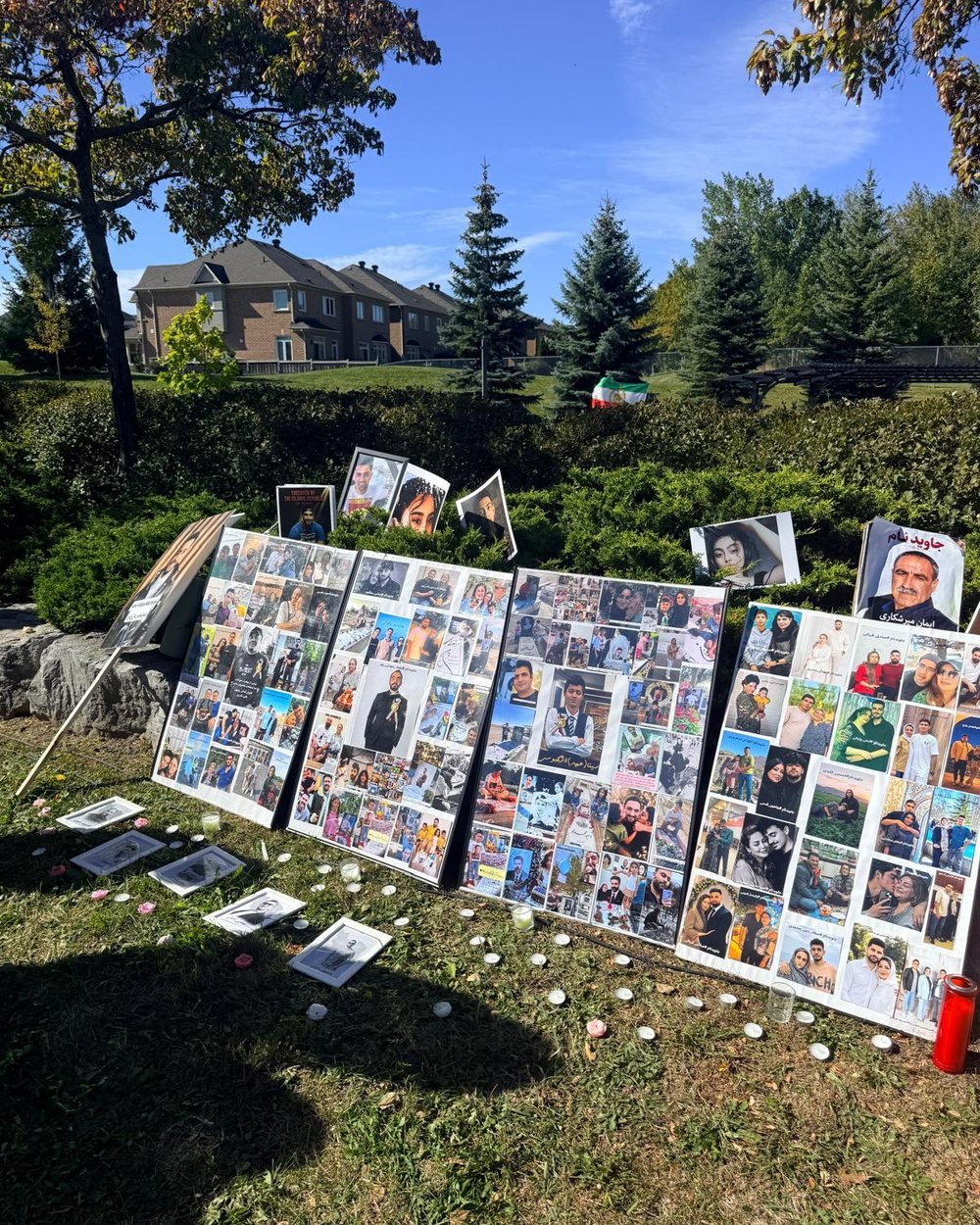 Memorial display boards carrying photographs of the victims, with candles placed in front